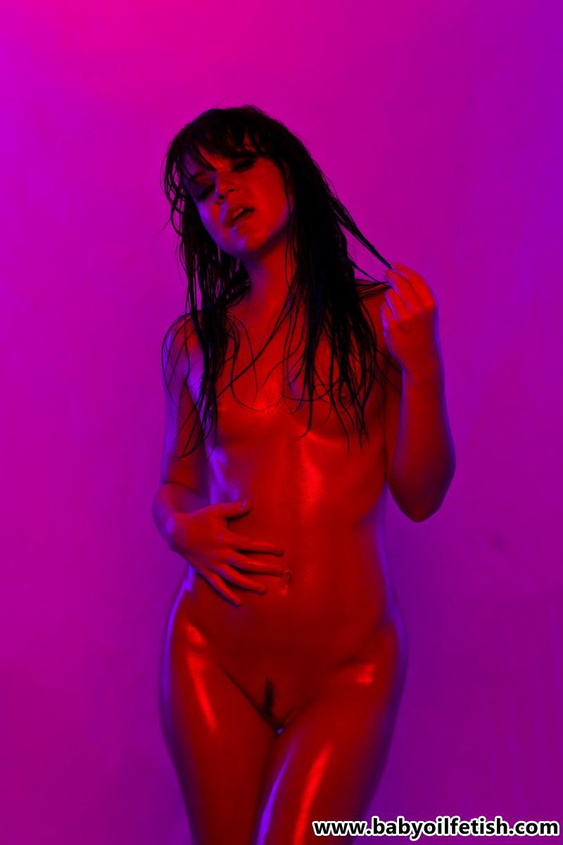 Brunette girl Jen covers herself in babyoil and poses in violet light #55232961