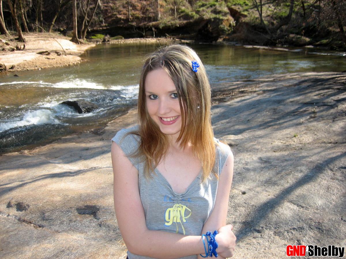Shelby, une jeune mignonne, exhibe ses petits seins dans le parc au bord du ruisseau.
 #58761841