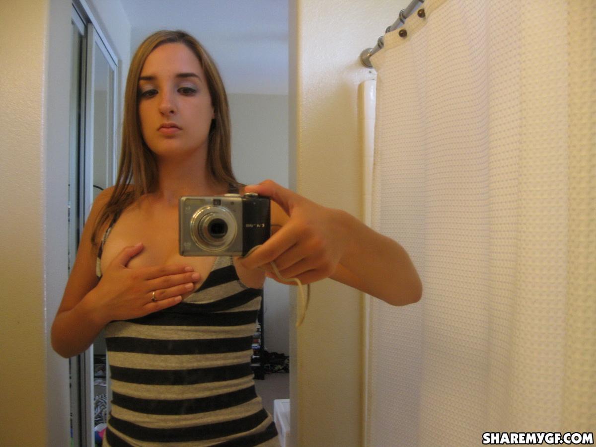 La ragazza carina mostra le sue tette vivaci e il suo culo rotondo mentre si fa delle foto allo specchio
 #60792418