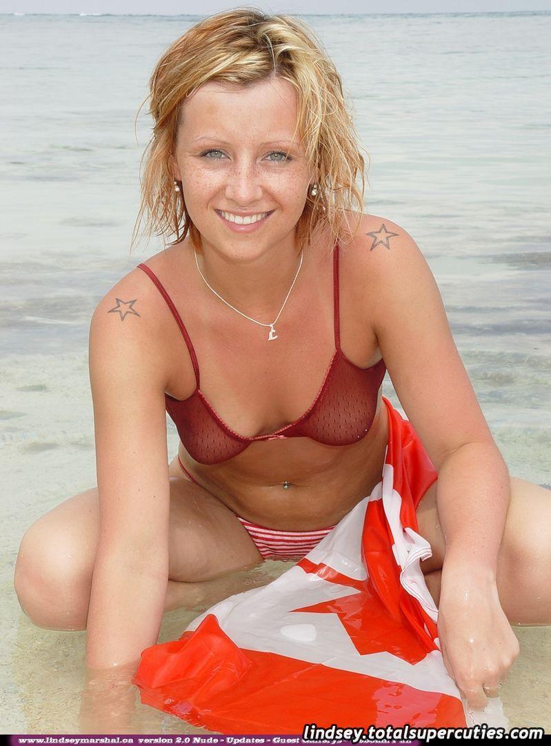ティーンの女の子リンジー・マーシャルが海辺でカナダの旗に包まれている写真
 #58975872