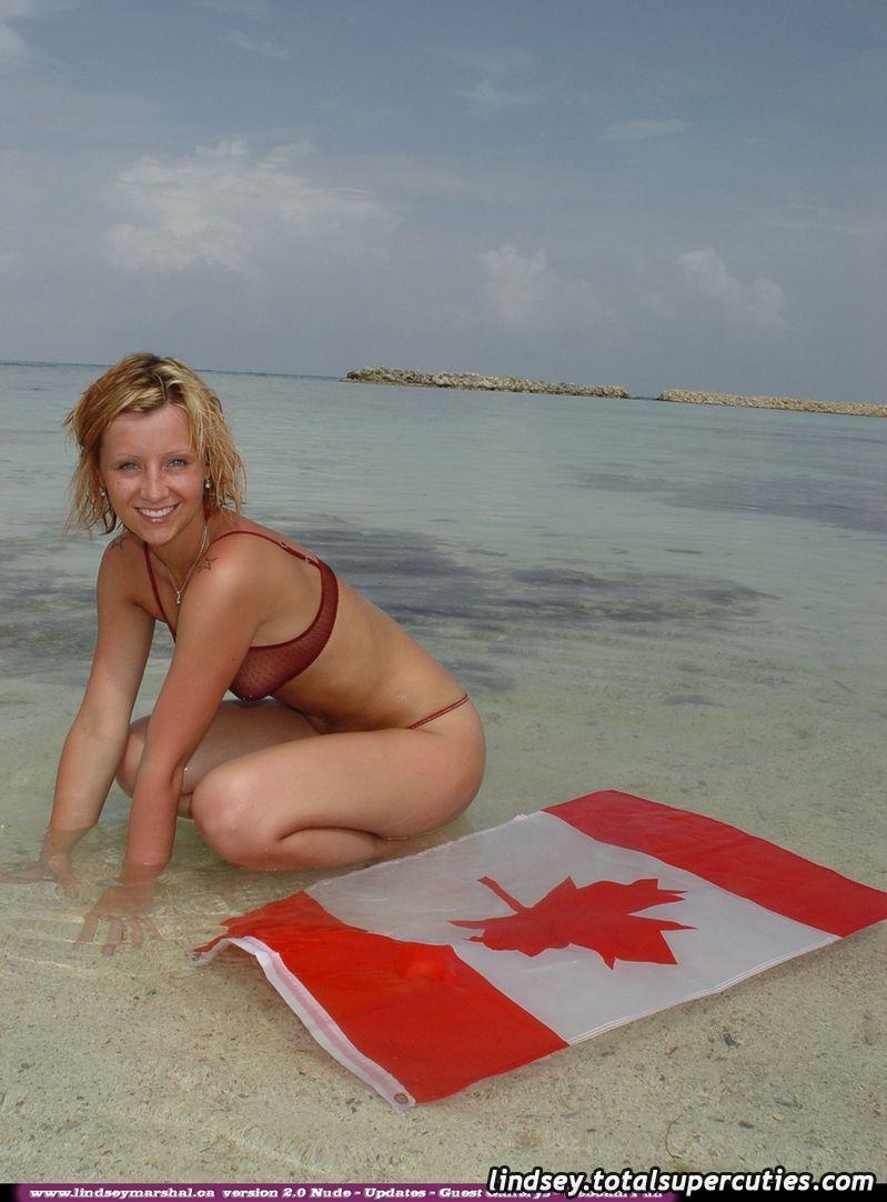Immagini di pulcino giovane Lindsey Marshal avvolto in una bandiera canadese sulla spiaggia
 #58975986
