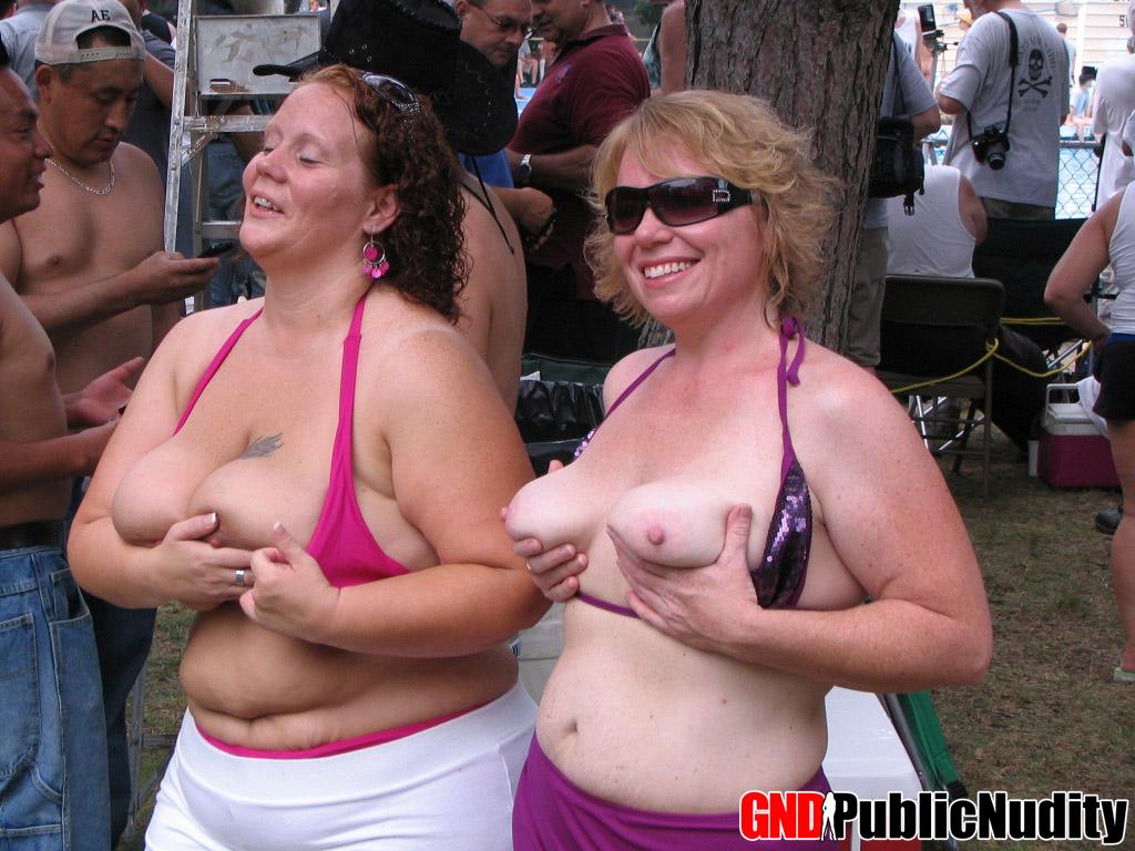 Mehrere Stripperinnen auf der Bühne zeigen ihr Können auf einer öffentlichen Nacktheitsparty im Freien
 #60507482