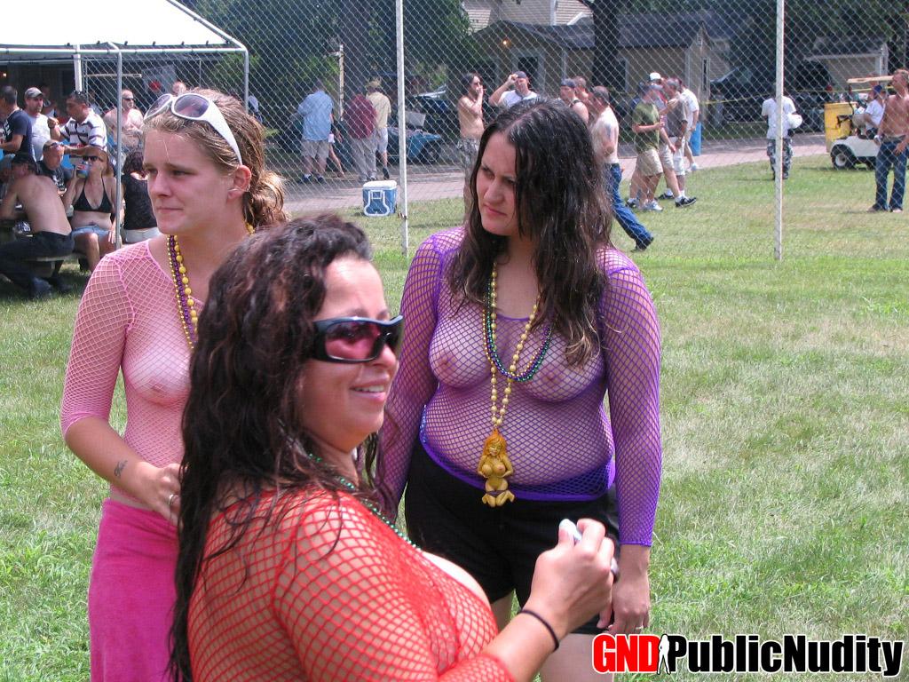 Mehrere Stripperinnen auf der Bühne zeigen ihr Können auf einer öffentlichen Nacktheitsparty im Freien
 #60507568