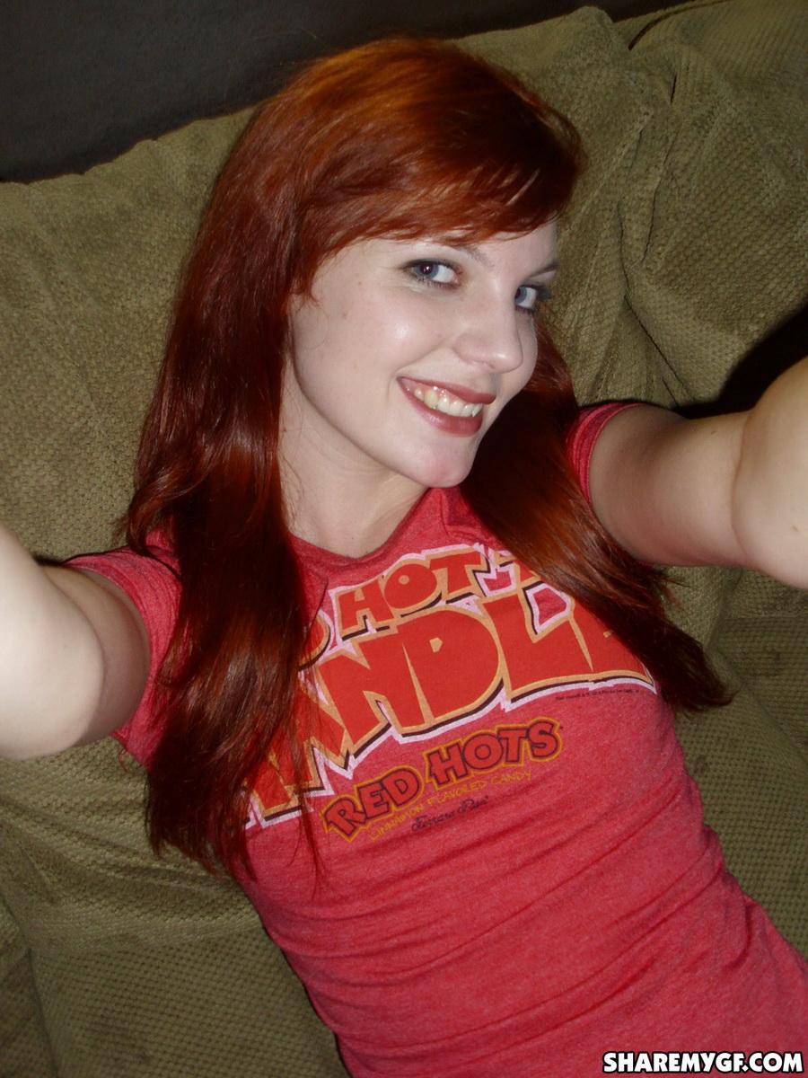 Redhead girlfriend takes selfshot pictures on the couch #60791091