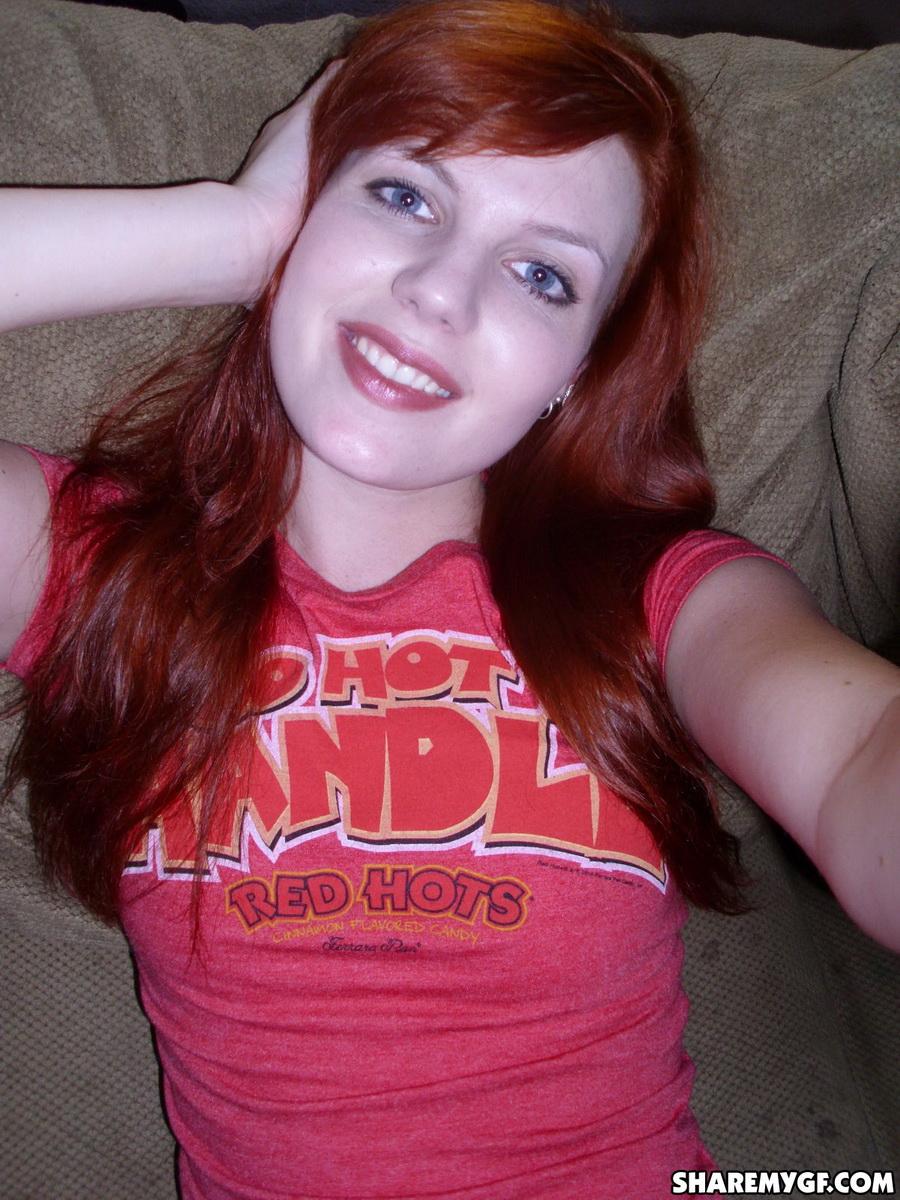 Une copine rousse prend des photos de soi sur le canapé
 #60791117