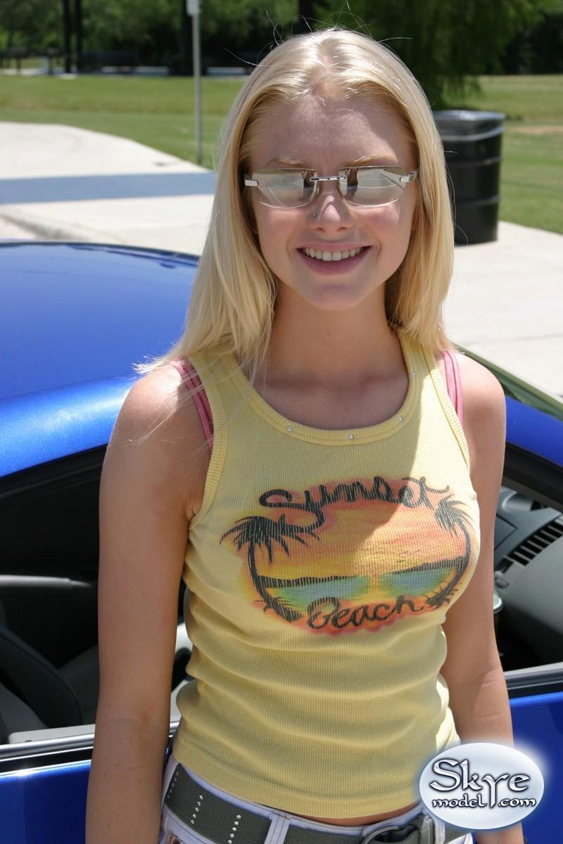 Une jeune blonde, Skye, montre son corps de jeune près de la voiture de ses amis.
 #59830403