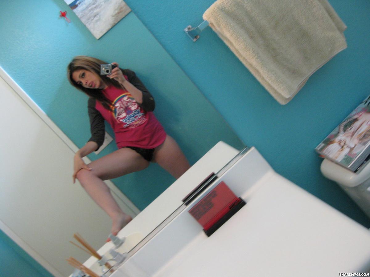 Une jeune femme brune sexy partage des selfies de son corps dans la salle de bain.
 #61972879