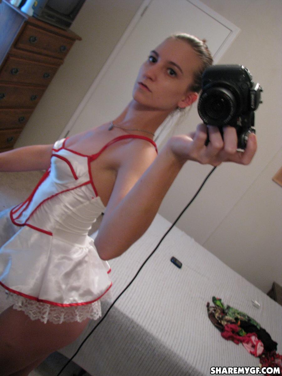 Novia delgada se desnuda de su traje de enfermera mientras se hace fotos en el espejo
 #60790920