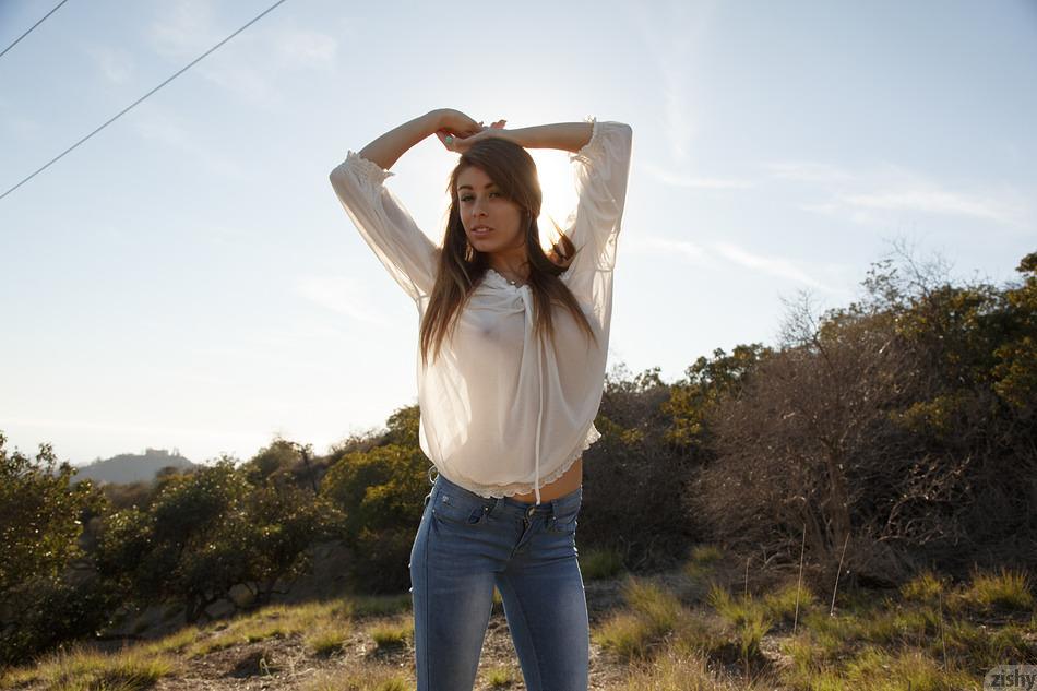 La joven pelirroja Gracie Thibble se burla en sus jeans azules al aire libre
 #60939943