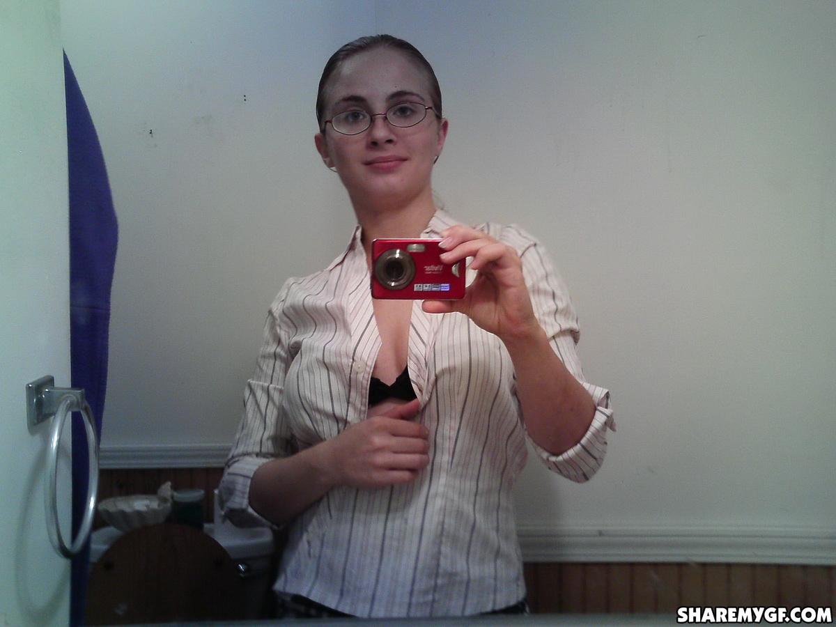 Geile Freundin zieht sich vor dem Spiegel aus ihrer Schuluniform aus, während sie Selfies macht
 #60791834
