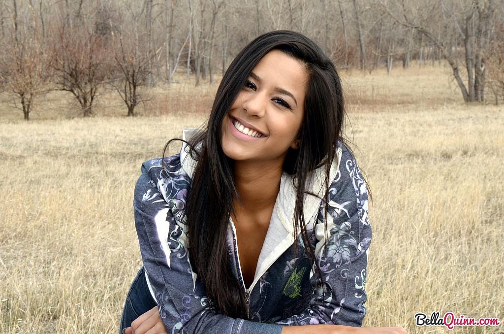 Bella Quinn, una joven morena, posa en un banco al aire libre
 #53432015