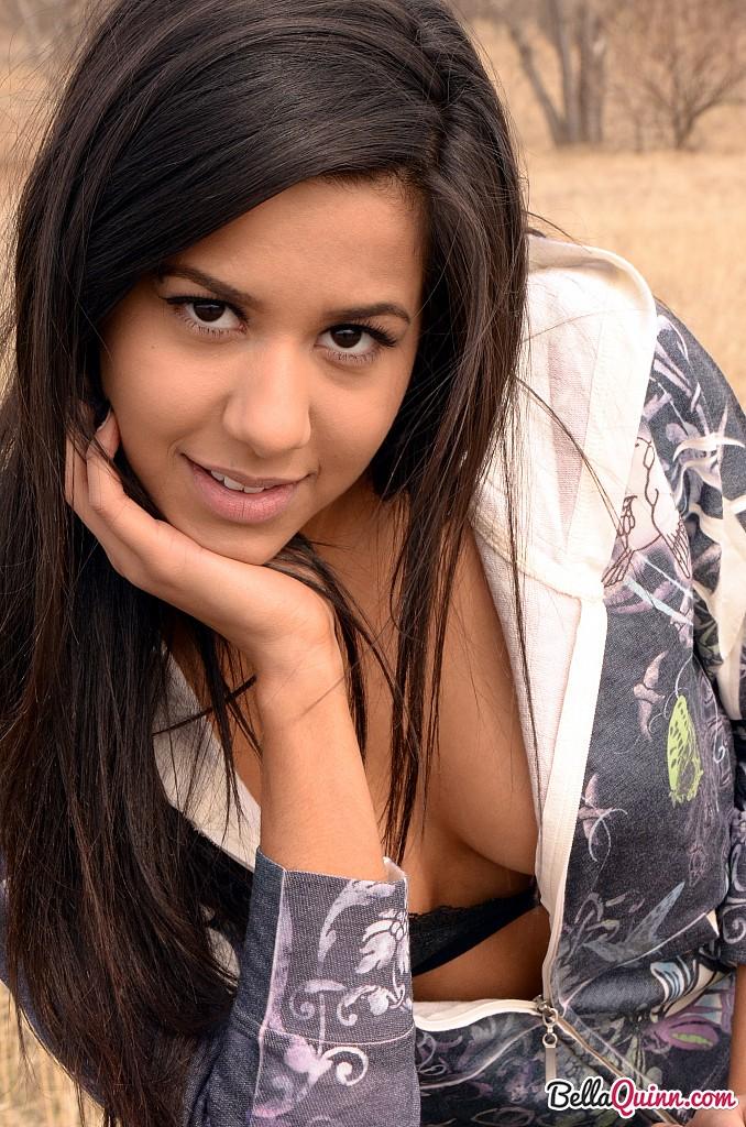 Bella Quinn, una joven morena, posa en un banco al aire libre
 #53432075