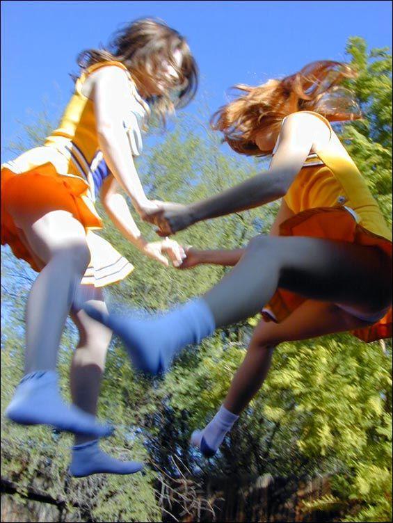 Pictures of two cheerleaders on a trampoline #60578423