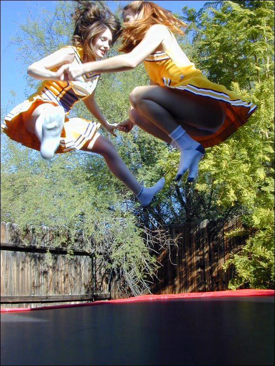 Pictures of two cheerleaders on a trampoline #60578433