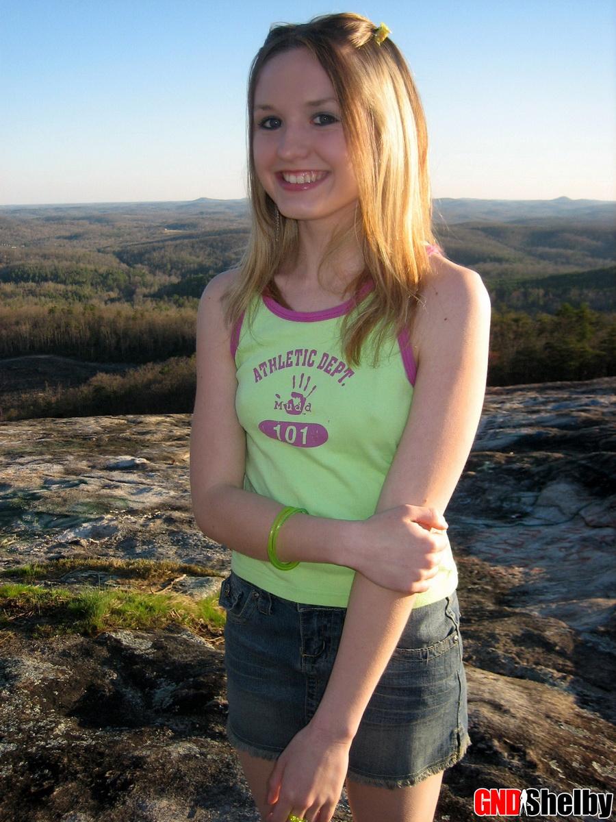 Shelby, une jeune pleine d'entrain, exhibe ses seins parfaits au sommet d'une montagne dans un parc public.
 #58762303