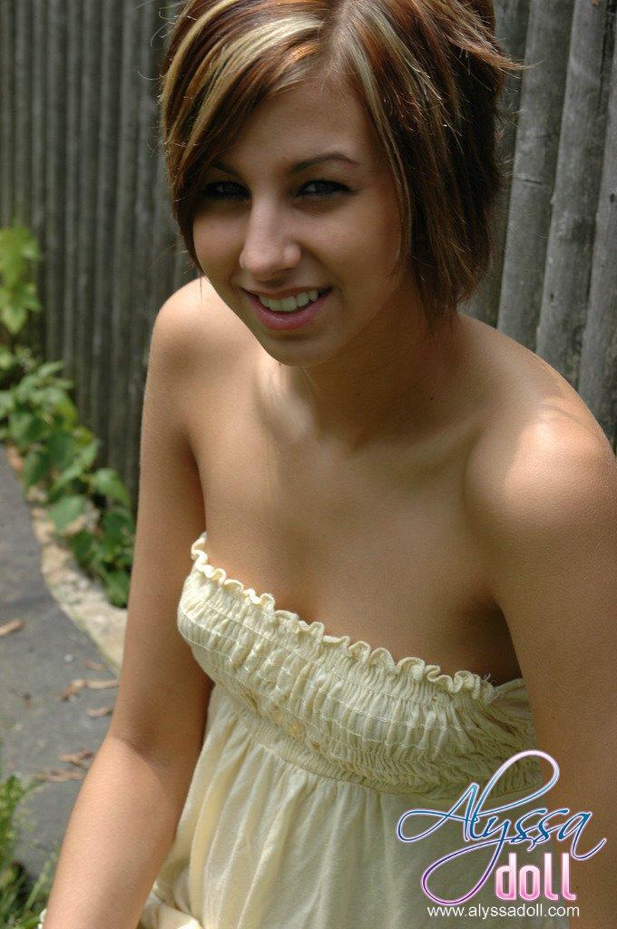 Alyssa posiert am Zaun in einem gelben Top und Jeansrock
 #53053574