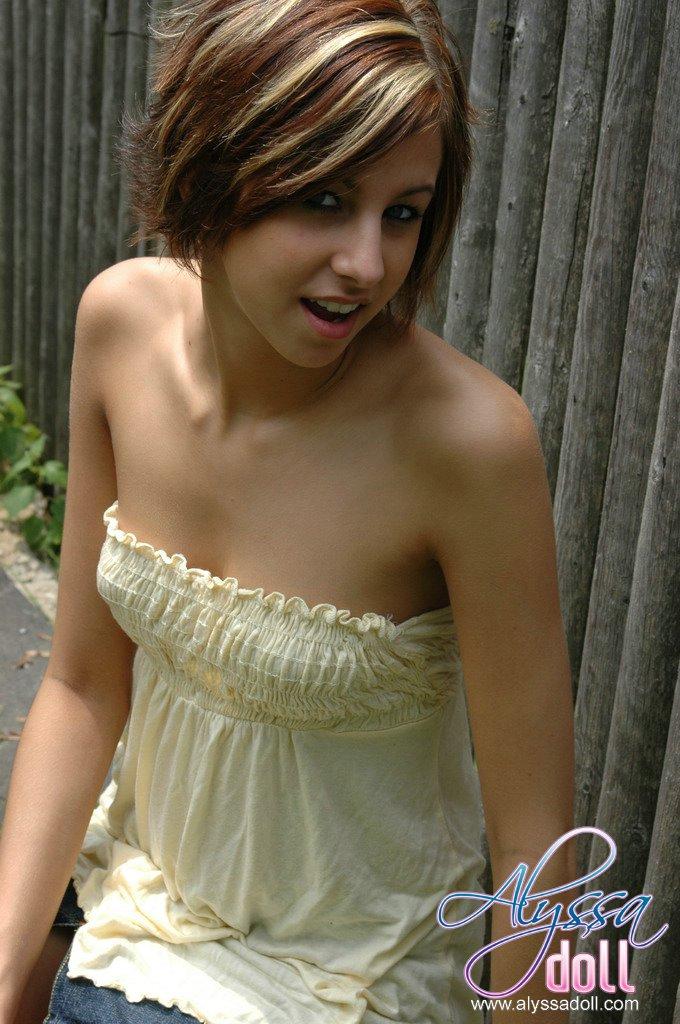 Alyssa posiert am Zaun in einem gelben Top und Jeansrock
 #53053601