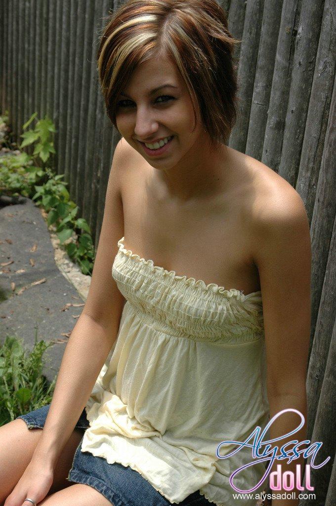 Alyssa poses by the fence in a yellow top and denim skirt #53053630