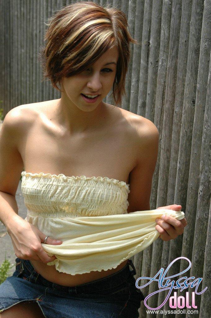 Alyssa poses by the fence in a yellow top and denim skirt #53053666