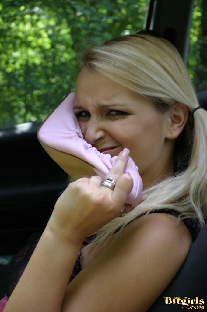 Une jeune blonde avec des nattes s'amuse avec ses pieds dans la voiture.
 #60255819