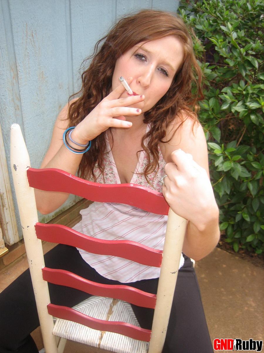 Ruby, une jeune rousse sexy, prend une pause cigarette et s'exhibe devant l'appareil photo.
 #59948397