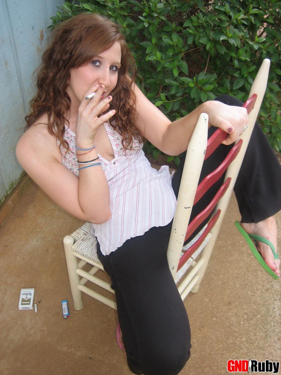 Ruby, une jeune rousse sexy, prend une pause cigarette et s'exhibe devant l'appareil photo.
 #59948404