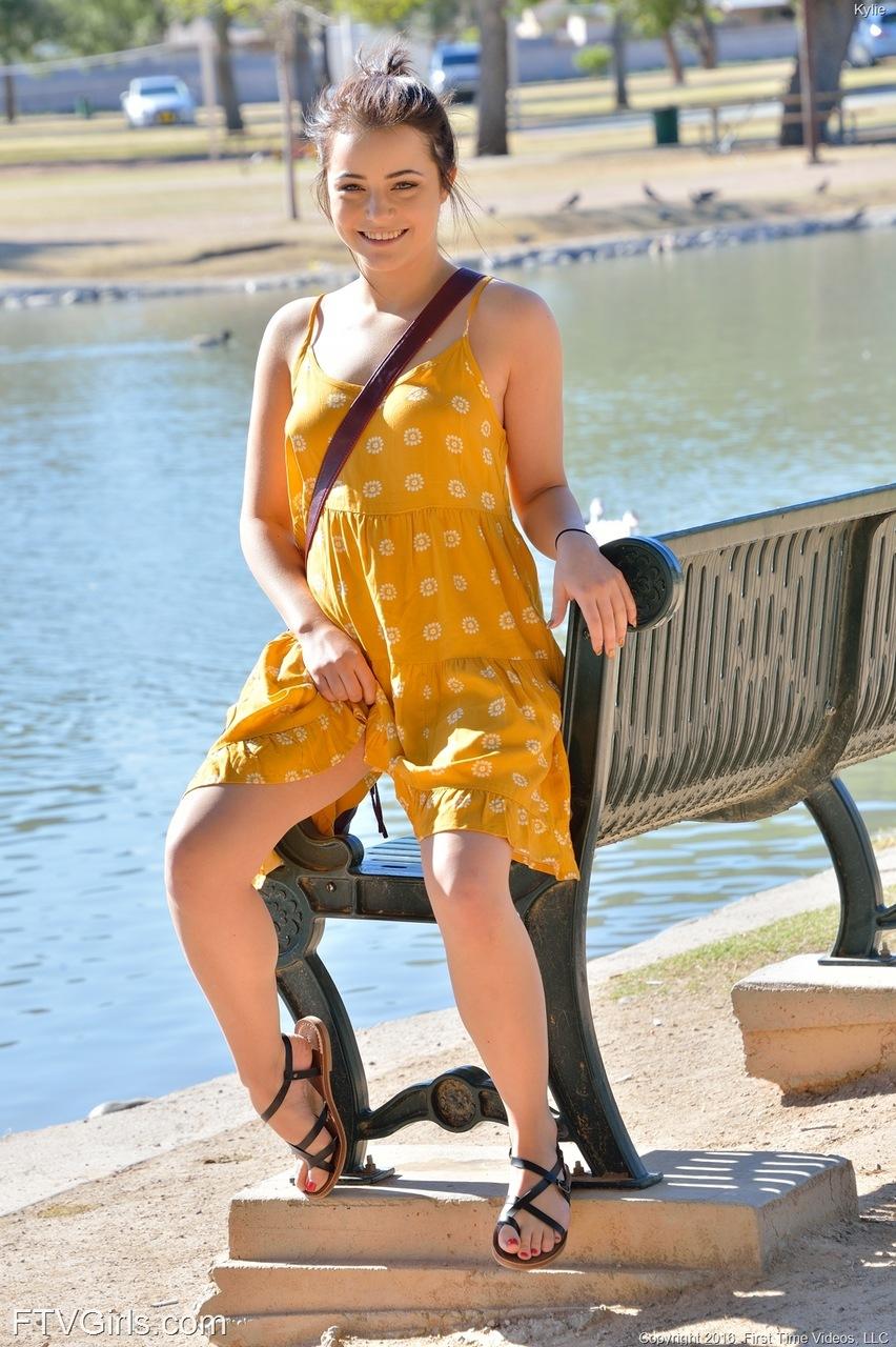 Kylie, jeune femme sexy, soulève sa robe jaune pour vous montrer sa chatte dans un parc public.
 #58785881