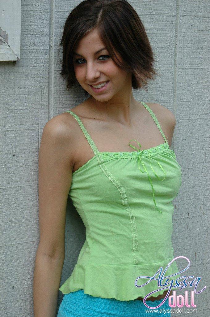 Alyssa si spoglia del suo vestito verde e blu vicino al muro
 #53054099