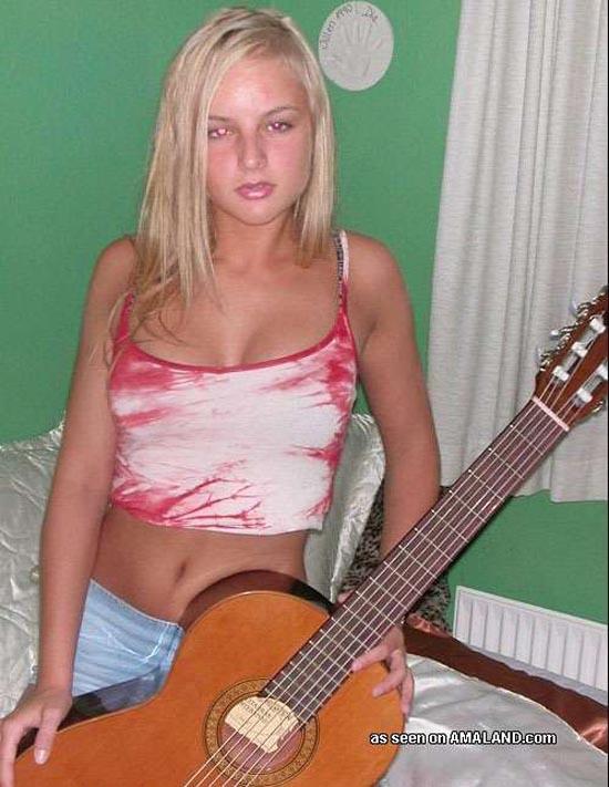 Mignonne blonde rockstar posant avec sa guitare
 #60657650