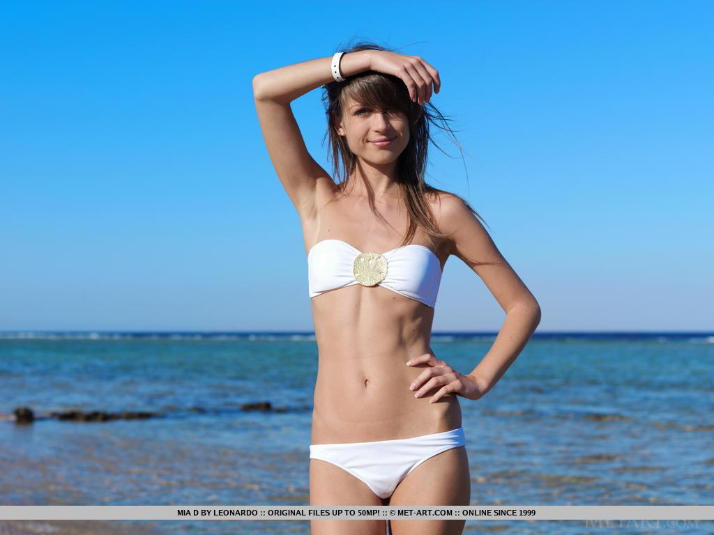 Teenager-Modell mia d Streifen aus ihrem weißen Bikini am Strand
 #59512116